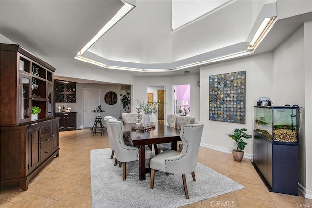 tiled dining room featuring a tray ceiling