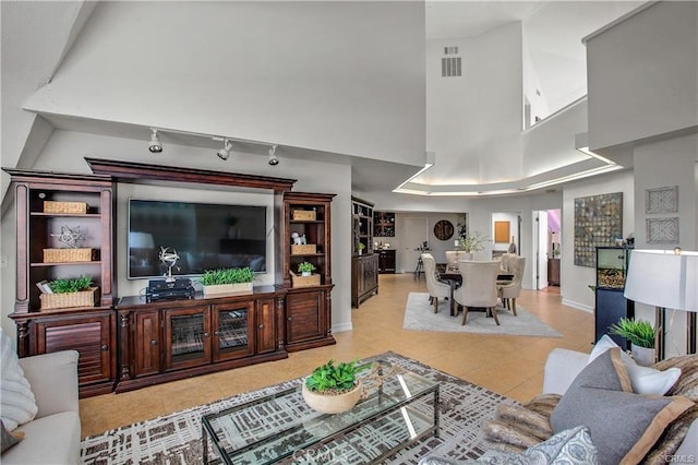 living room with a high ceiling and light tile patterned floors