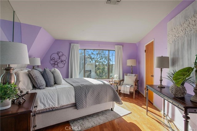 bedroom featuring vaulted ceiling and wood-type flooring