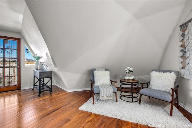 sitting room with vaulted ceiling and wood-type flooring