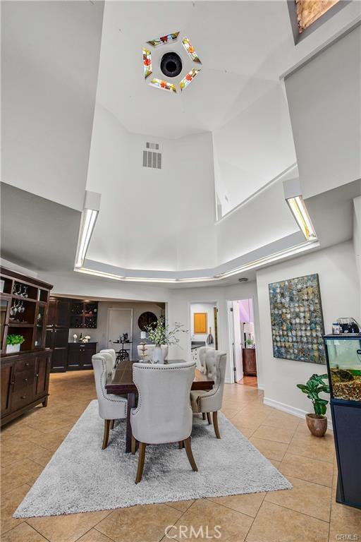 tiled dining area featuring a towering ceiling