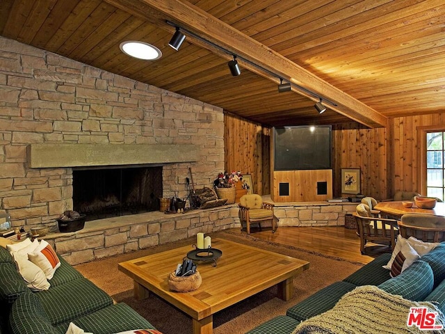 living room featuring a fireplace, wood walls, vaulted ceiling with beams, and hardwood / wood-style flooring