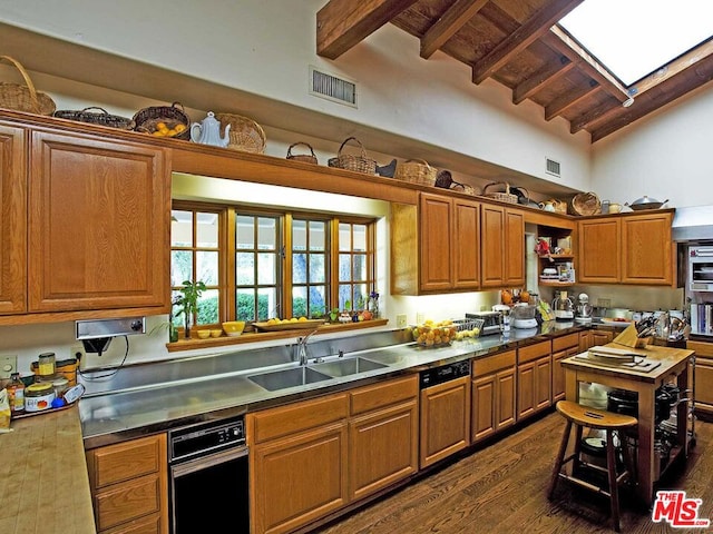 kitchen featuring vaulted ceiling with skylight, dishwasher, dark wood-type flooring, and sink