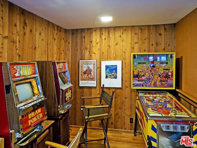 playroom with wood walls and light wood-type flooring