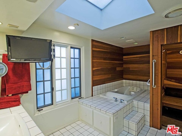 interior space with plenty of natural light, a skylight, tile flooring, and wood walls