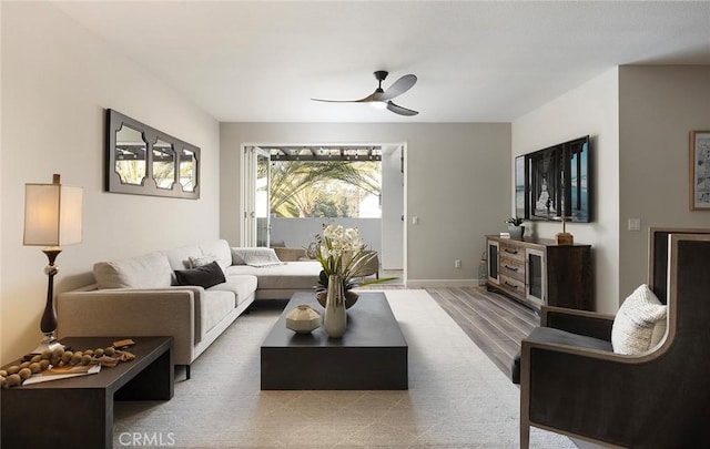 living area with ceiling fan, baseboards, and wood finished floors