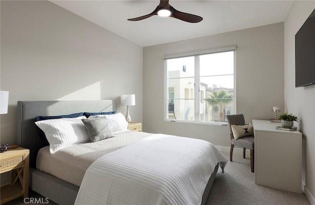 carpeted bedroom with ceiling fan and baseboards