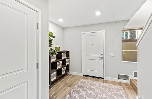 entryway with wood tiled floor, baseboards, and recessed lighting