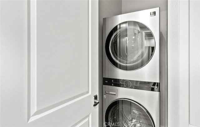 washroom featuring stacked washer and dryer and laundry area