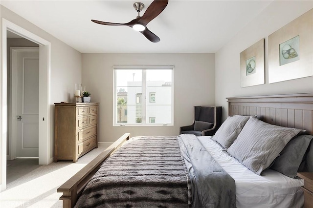 bedroom with ceiling fan, baseboards, and light colored carpet