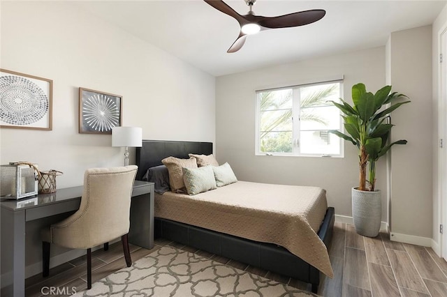 bedroom featuring wood tiled floor, baseboards, and ceiling fan