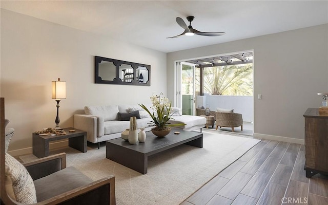 living room featuring baseboards, a ceiling fan, and wood tiled floor