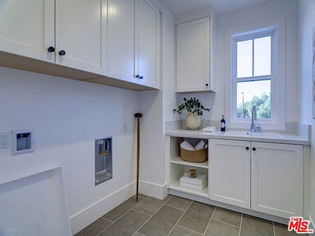 washroom featuring washer hookup, dark tile flooring, cabinets, and sink