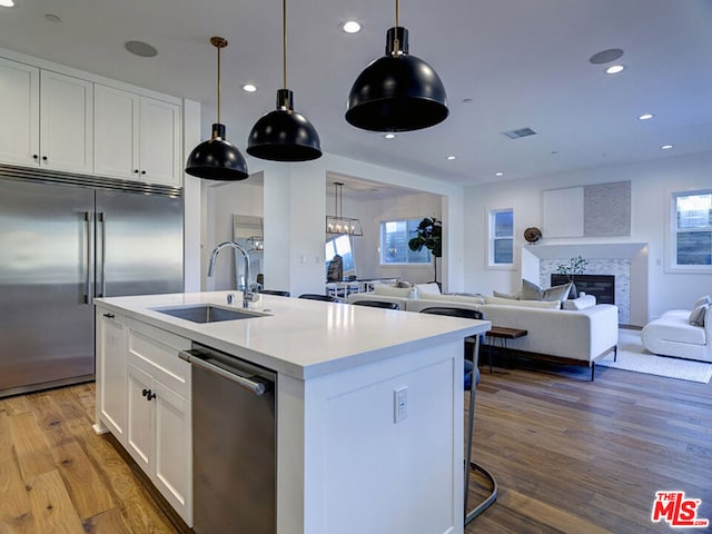 kitchen with pendant lighting, dark hardwood / wood-style floors, stainless steel appliances, and white cabinetry