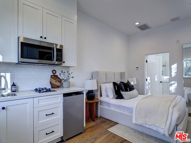 bedroom with sink and hardwood / wood-style flooring