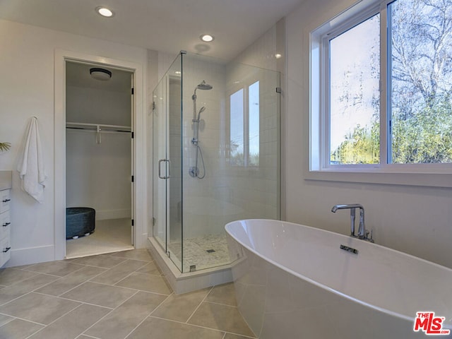 bathroom featuring shower with separate bathtub and tile floors