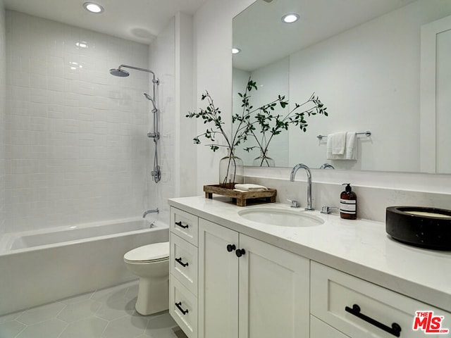 full bathroom with tiled shower / bath combo, tile floors, toilet, and vanity