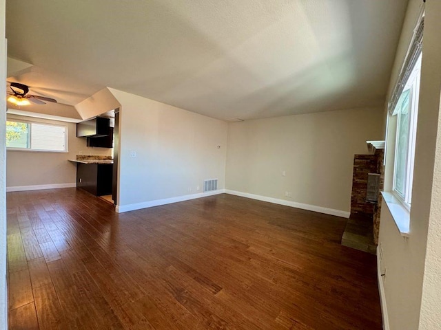 unfurnished living room featuring ceiling fan and dark hardwood / wood-style floors