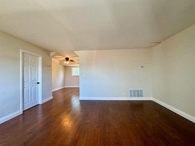 empty room with ceiling fan, dark hardwood / wood-style floors, and a textured ceiling