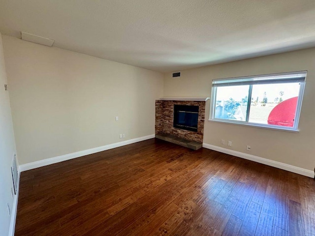 unfurnished living room with a fireplace and dark hardwood / wood-style flooring