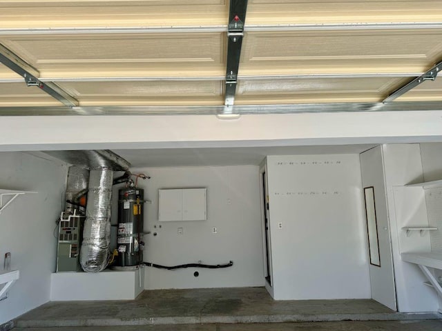 garage featuring heating unit and strapped water heater