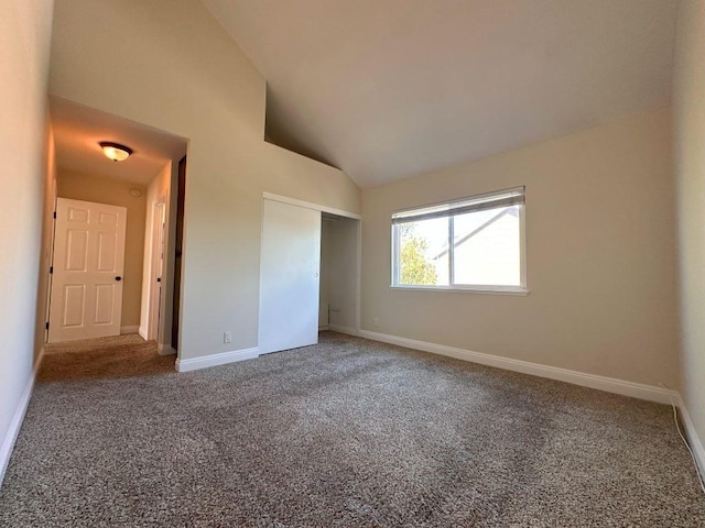 unfurnished bedroom featuring carpet floors, high vaulted ceiling, and a closet