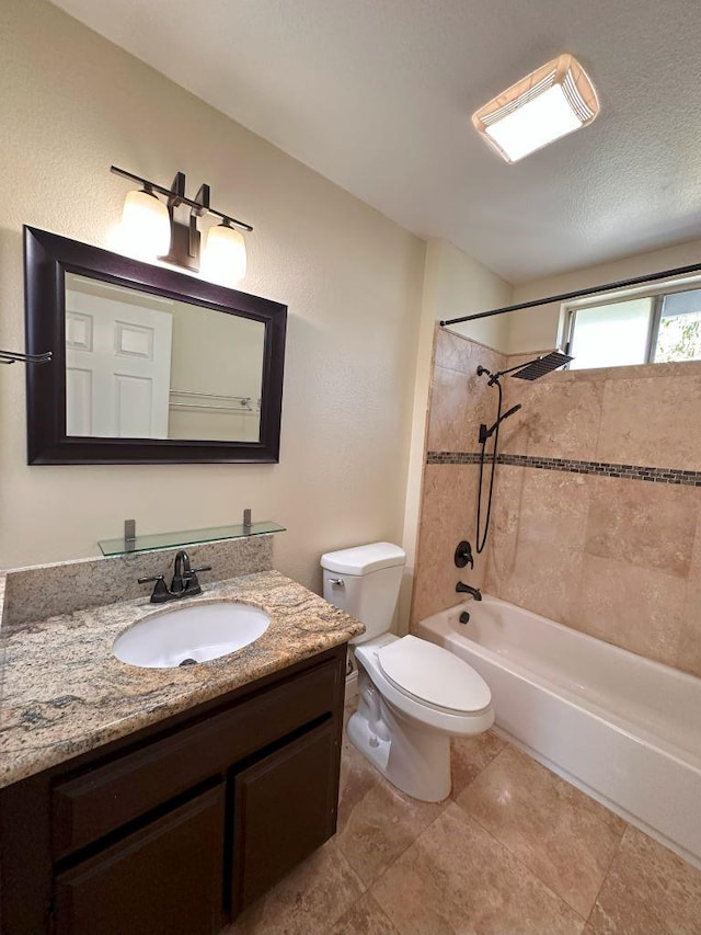 full bathroom featuring tiled shower / bath combo, vanity, a textured ceiling, and toilet