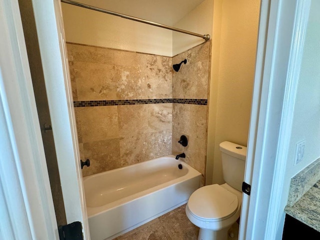 bathroom featuring tile patterned floors, toilet, and tiled shower / bath