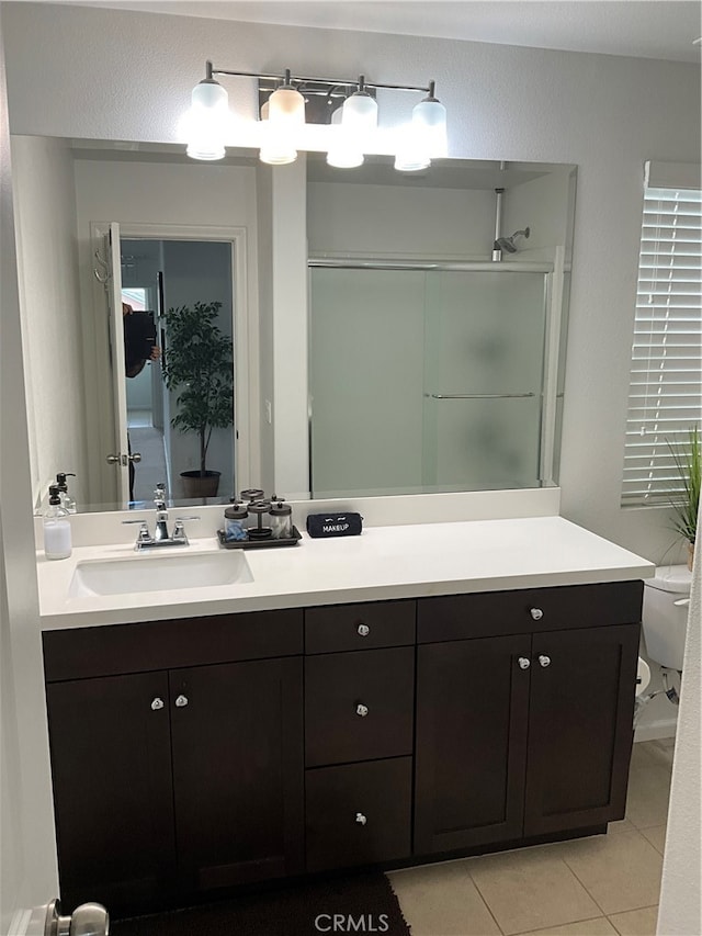 bathroom featuring toilet, tile floors, and vanity