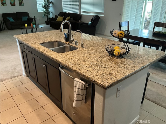 kitchen featuring light stone countertops, a kitchen island with sink, sink, stainless steel dishwasher, and light colored carpet