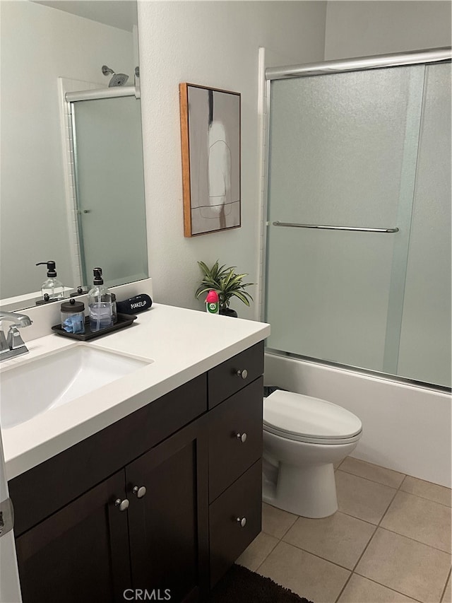 full bathroom with shower / bath combination with glass door, toilet, tile floors, and large vanity