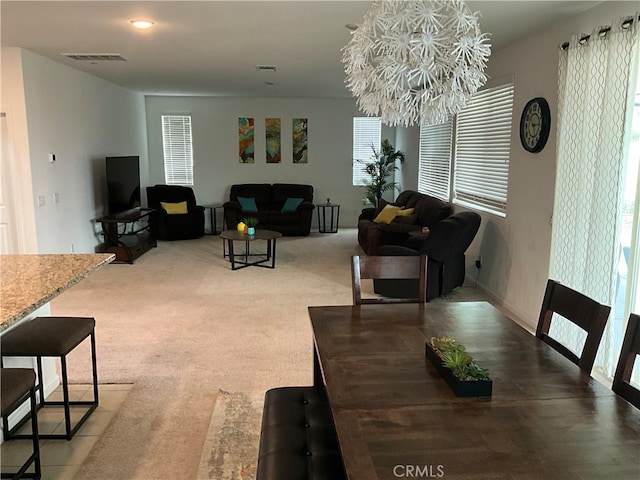 dining area with a notable chandelier and carpet