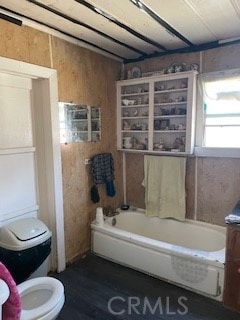 bathroom with wood walls and toilet