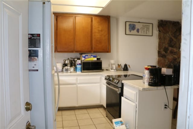 kitchen featuring white fridge, range with electric cooktop, and light tile floors