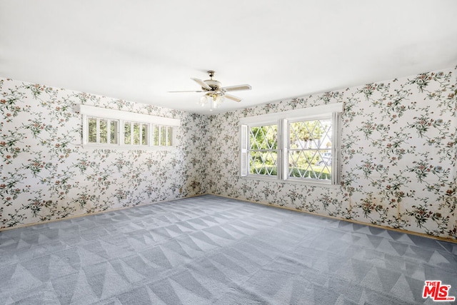 carpeted spare room featuring ceiling fan