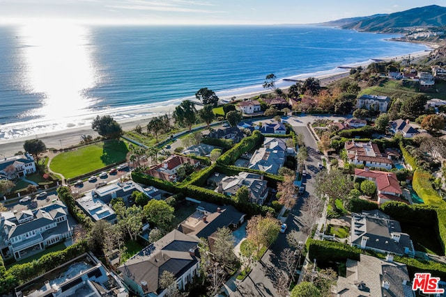 bird's eye view featuring a water view and a beach view