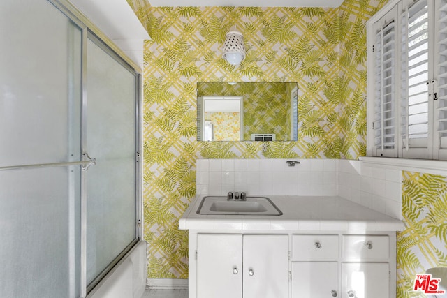 bathroom with vanity, shower / bath combination with glass door, and a wealth of natural light