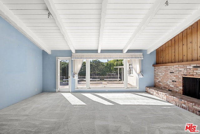 unfurnished living room featuring beam ceiling, a fireplace, and carpet