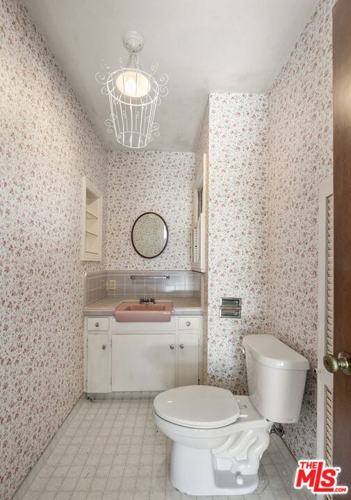 bathroom with vanity, tasteful backsplash, and toilet