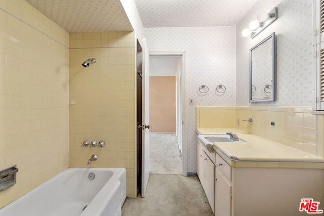 bathroom featuring vanity and tiled shower / bath