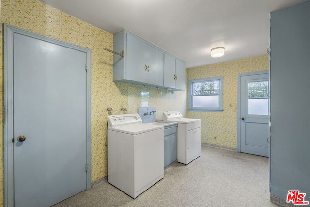 laundry area featuring washer and clothes dryer and cabinets