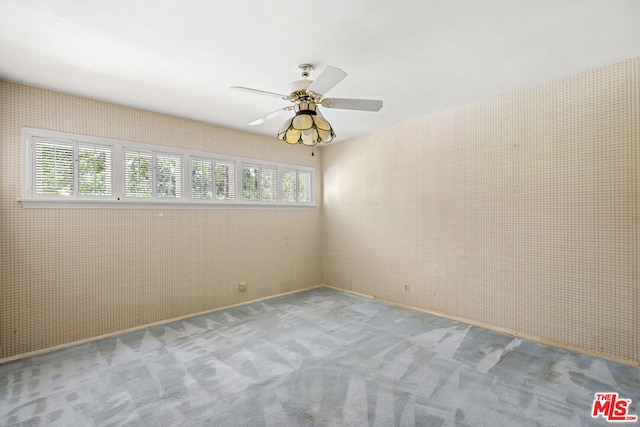 carpeted empty room featuring ceiling fan