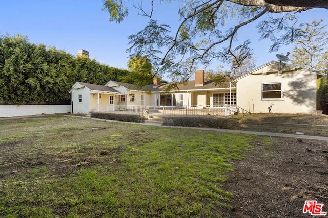 rear view of property with a yard and a porch