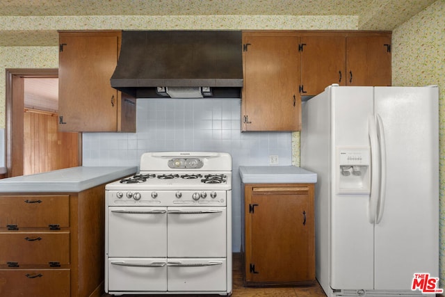 kitchen featuring white appliances, tasteful backsplash, and wall chimney range hood