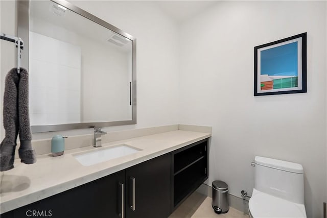 bathroom with toilet, tile patterned flooring, and vanity