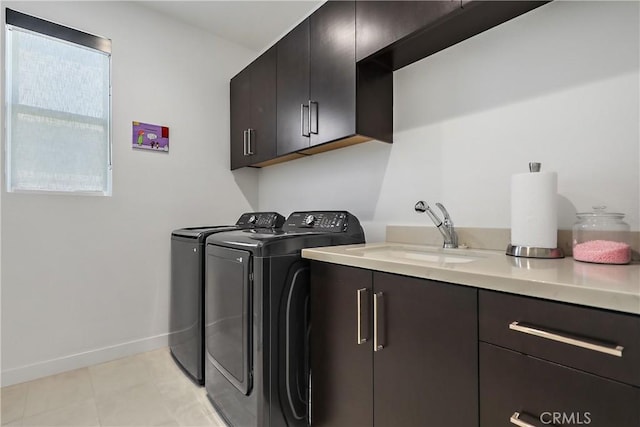 laundry room featuring sink, washing machine and dryer, and cabinets