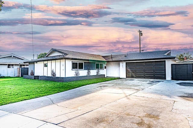 ranch-style home with a garage and a yard