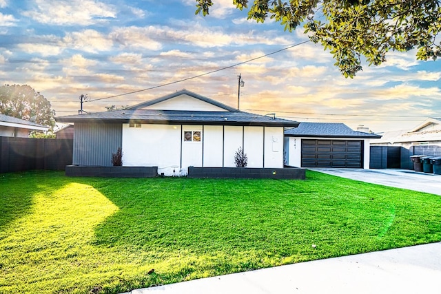 ranch-style home featuring a garage and a yard