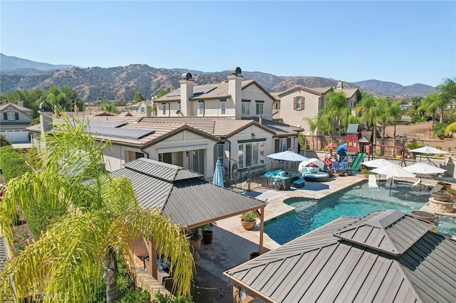 exterior space with pool water feature, a patio, and a mountain view