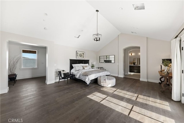 bedroom with dark wood-type flooring, lofted ceiling, and a chandelier